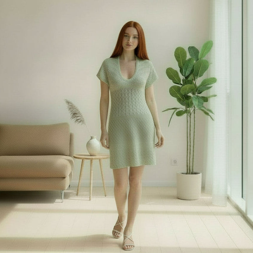 woman with red hair wearing a light green lace detailed dress in a living room
