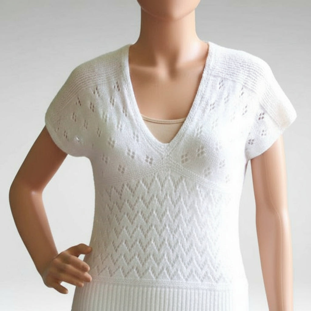 White knit dress with lace pattern on a mannequin against a white background