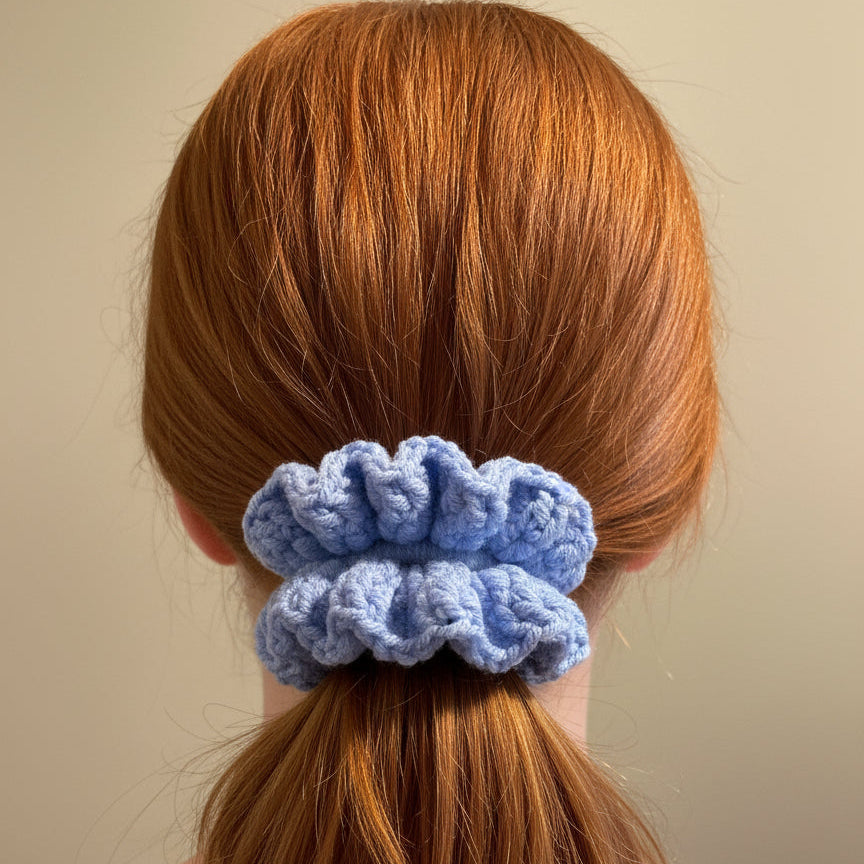 Blue crocheted scrunchie on a woman with red hair
