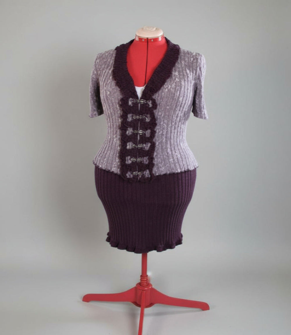 Purple and gray textured dress on a mannequin with a red base against a plain background